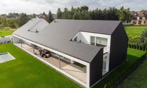 Nowoczesny dom z dachem stojącym, tarasem i basenem.