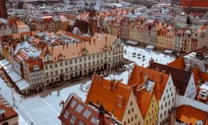 Widok z góry na Rynek we Wrocławiu z kolorowymi kamienicami i ratuszem.