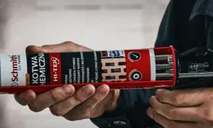 Dłoń trzyma pistolet z kartuszem kotwy chemicznej, gotowa do użycia kotwy murarskie do mocowania elementów.