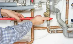 Hydraulik z kluczem nastawnym naprawia instalację wodną.