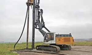 Palownica z operatorem w kabinie, pracująca na budowie.
