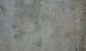 Szara, chropowata powierzchnia betonu z widocznymi nierównościami i śladami po szalunku.