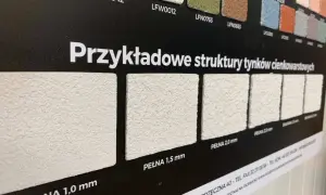 Próbki tynków elewacyjnych o różnych fakturach i grubościach ziarna.
