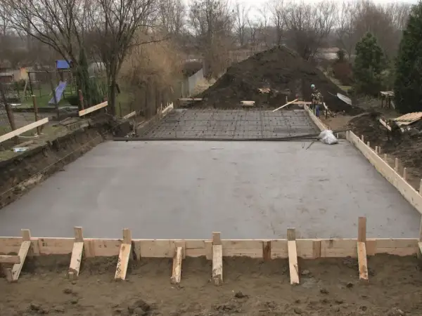 Plac budowy z wylana betonowa płyta fundamentowa i zbrojenie.