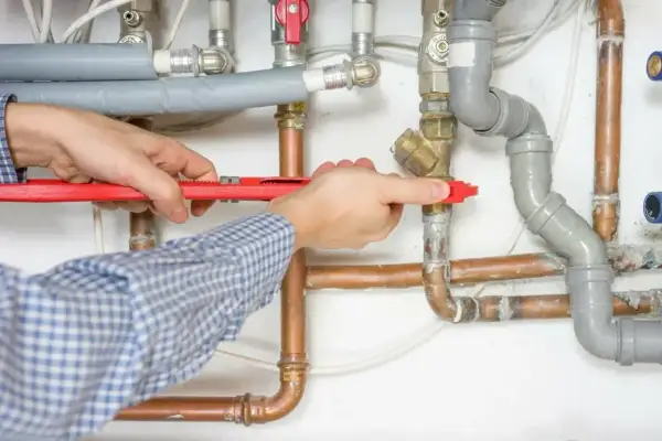 Hydraulik z kluczem nastawnym naprawia instalację wodną.