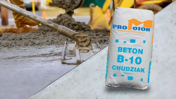 Wylewanie i wyrównywanie betonu na podbudowie, obok worek z betonem B-10 Chudziak.